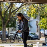 Person cleaning ground with power washer